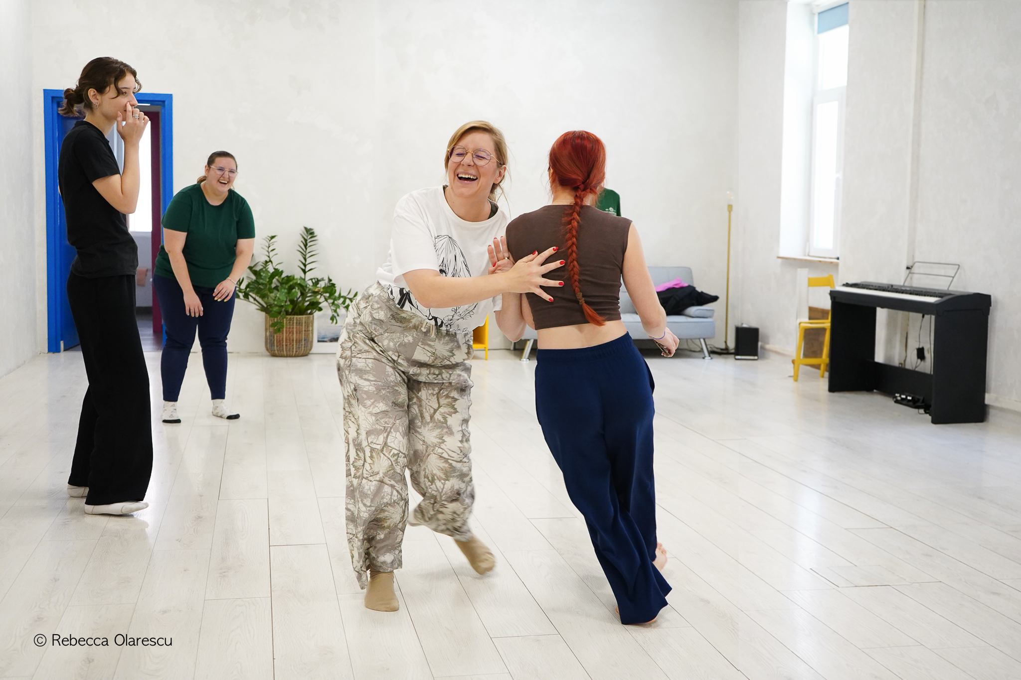 Grup dansând liber într-un studio luminat cald
